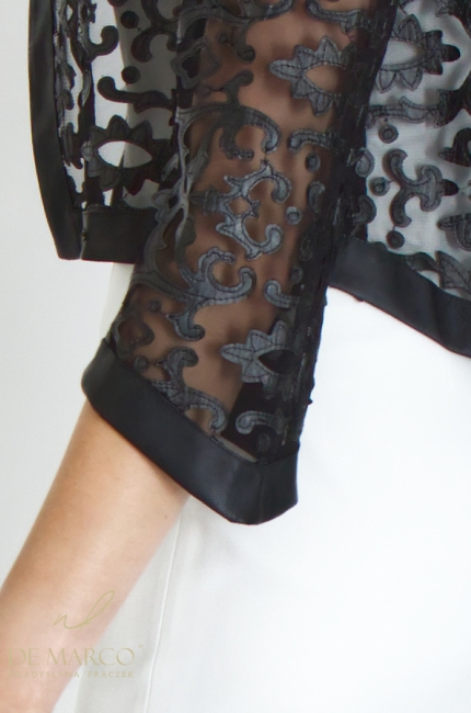 Luksusowa czarna narzutka bolerko koronkowa ze skóry ekologicznej w zestawie z klasyczną prostą sukienką mini wizytową w kolorze śmietanowej bieli. Szycie na miarę De Marco